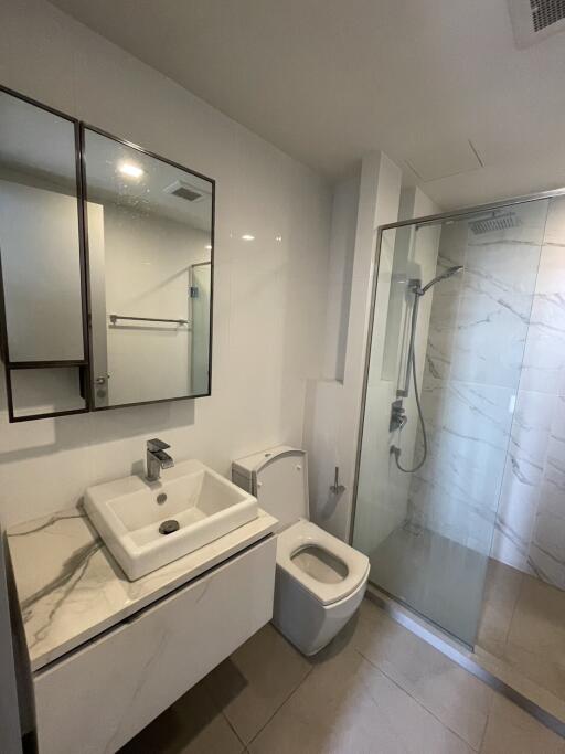 Modern bathroom with a shower, toilet, and sink