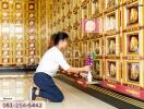 Person placing flowers in front of golden niches