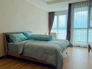 Modern bedroom with large windows and blue bedding