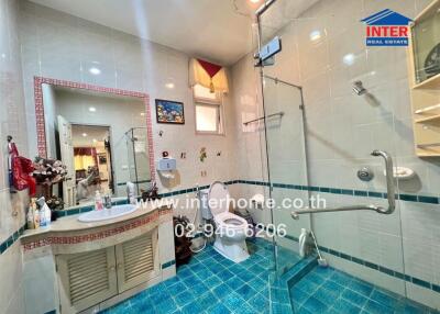Bright and modern bathroom with blue tiles and glass shower