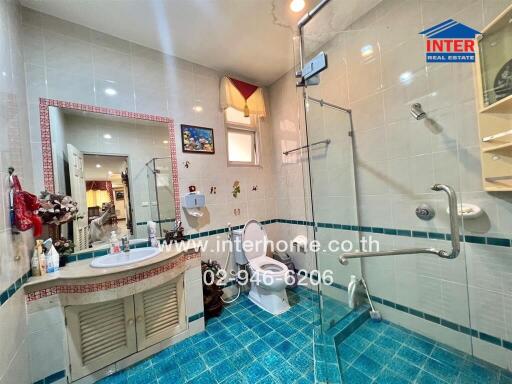 Bright and modern bathroom with blue tiles and glass shower