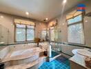 Spacious bathroom with white and blue tiles, large bathtub, and glass-enclosed shower area