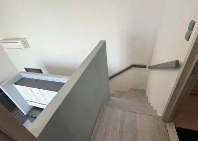 Modern staircase leading downstairs with air conditioning unit visible