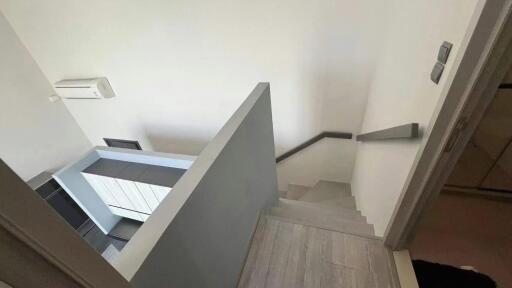 Modern staircase leading downstairs with air conditioning unit visible