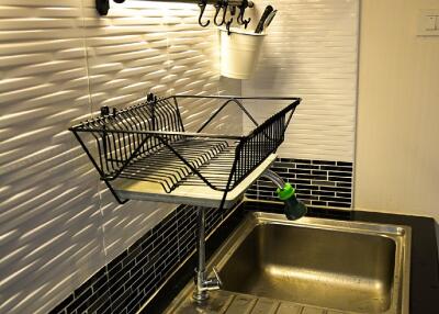 Modern kitchen area with sink and dish rack