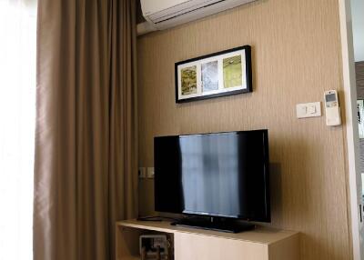 Living room with television, air conditioner, and decor