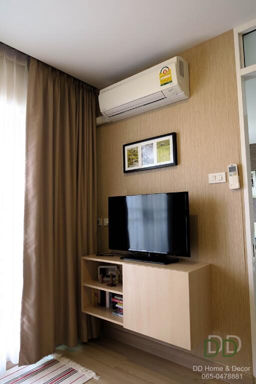 Living room with television, air conditioner, and decor