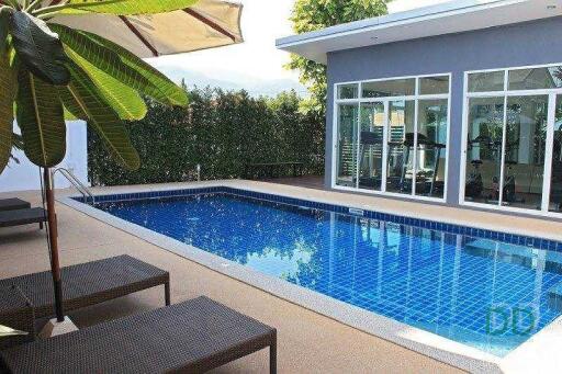 Outdoor pool with sun loungers and a seating area