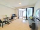 Well-lit living room with adjacent bedroom, featuring modern furniture and sleek design