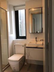 Modern bathroom with glass shower, square sink, and window