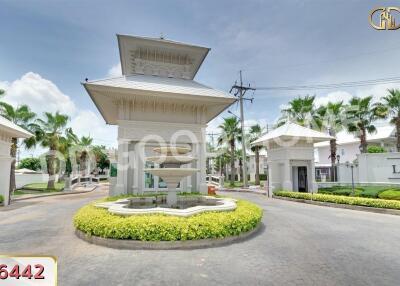 Entrance gate with a fountain and landscaped greenery