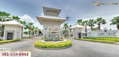 Entrance gate with a fountain and landscaped greenery