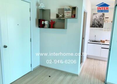 Entryway with bookshelf and view into kitchen