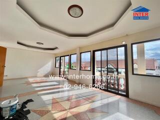 Spacious living room with large windows and unique ceiling design