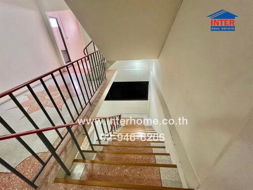 Interior staircase area with railing and multiple levels