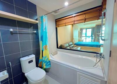 Modern bathroom with bathtub and view into bedroom