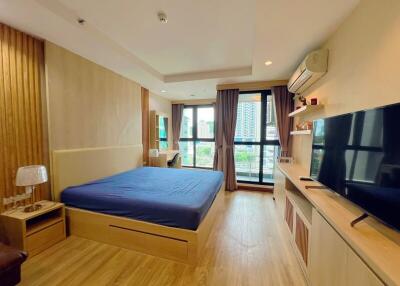 Modern bedroom with large bed, window view, and wooden flooring