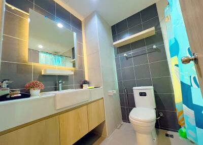Modern bathroom with large mirror and tiled walls