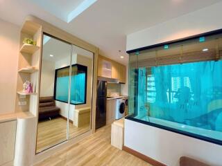 modern apartment living area with sliding mirror doors, couch, large window, washing machine, refrigerator, and aquarium