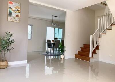 Dining area with hanging lights, staircase, and partial view of living space