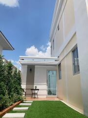 Side view of a modern two-story house with a small patio area