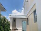 Side view of a modern two-story house with a small patio area