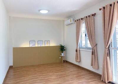 Spacious living room with wooden flooring and large windows