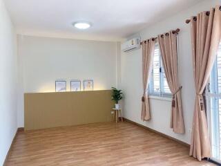 Spacious living room with wooden flooring and large windows