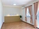 Spacious living room with wooden flooring and large windows