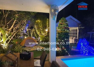 Outdoor area with garden, pool, lights, and a tent setup