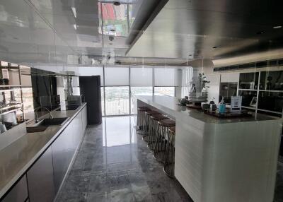 Spacious modern kitchen with large windows and a breakfast bar