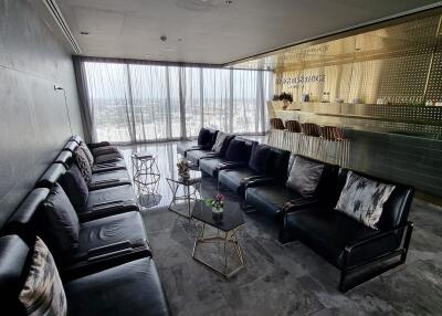 Modern living space with black leather sofas and bar area