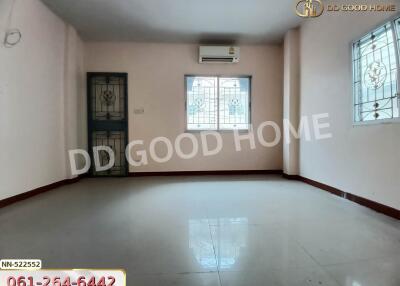 Spacious living room with tiled floor, windows with grills, and air conditioner