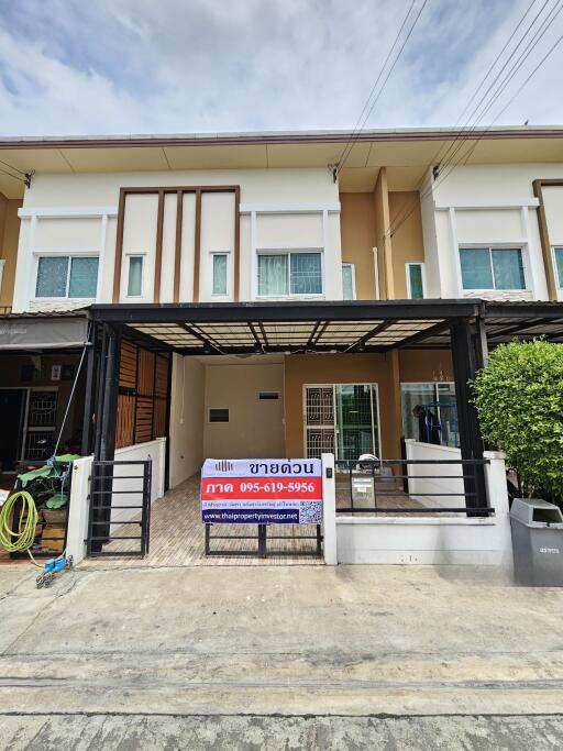 Front view of a two-story townhouse with a gated entrance