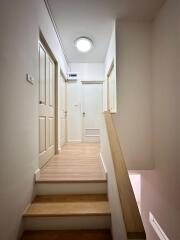 A hallway with beige doors and wooden flooring