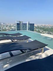 Modern rooftop swimming pool area with lounge chairs and city views