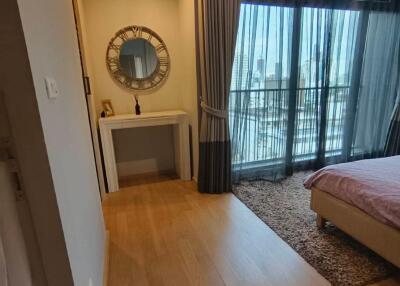 Modern bedroom with wooden flooring, large window, and balcony access