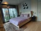 Cozy bedroom with a large bed, decorative butterflies on the wall, and balcony access.