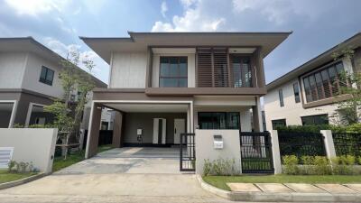 A modern two-story house with a driveway and small green lawn