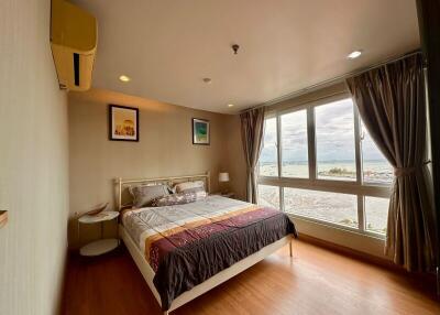 Spacious bedroom with a large window and scenic view
