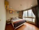Spacious bedroom with a large window and scenic view