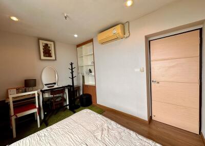 Bedroom with wooden flooring, study desk, air conditioner, and built-in shelves