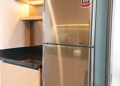 Modern kitchen with stainless steel refrigerator and wooden cabinets