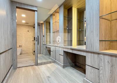 Spacious and modern bathroom with wooden cabinets and glass shelving