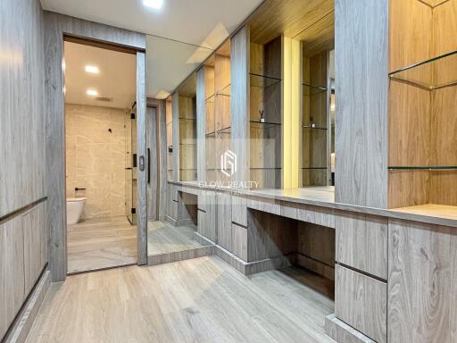 Spacious and modern bathroom with wooden cabinets and glass shelving