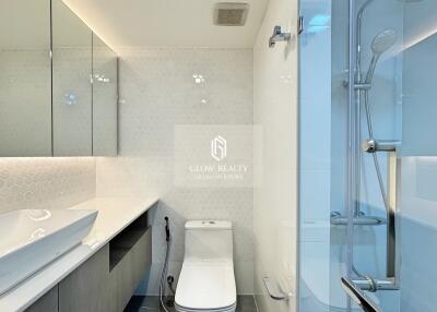 Modern bathroom with glass shower, toilet, and spacious vanity sink
