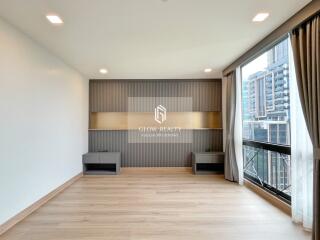 Modern living room with large windows, wooden flooring, and built-in storage