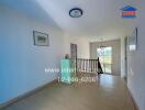 Bright hallway with wooden flooring and a staircase railing