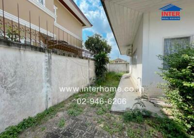 Outdoor view of a residential property including a walkway and some greenery