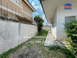 Outdoor view of a residential property including a walkway and some greenery